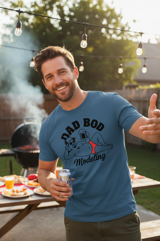 Model wearing Rock this Dadbod T-shirt in steel blue at a backyard BBQ